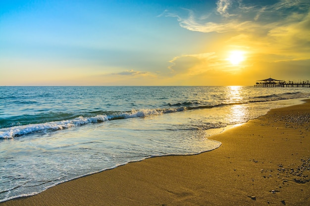 Belo pôr do sol dourado na praia, costa de belek, turquia