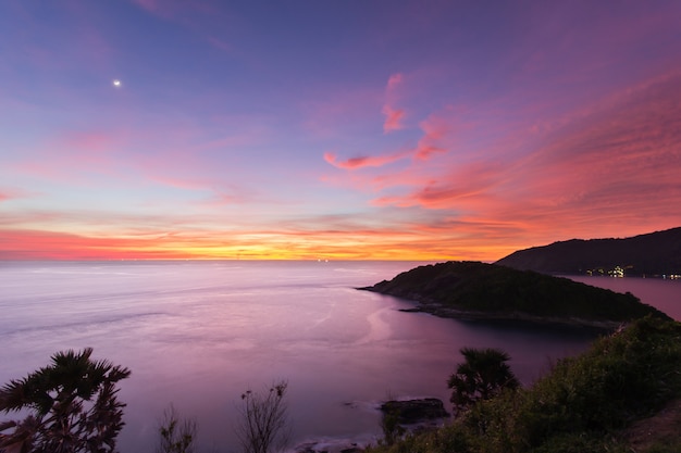 Belo pôr do sol na capa promthep é uma montanha de rocha que se estende para o mar em Phuket, Tailândia