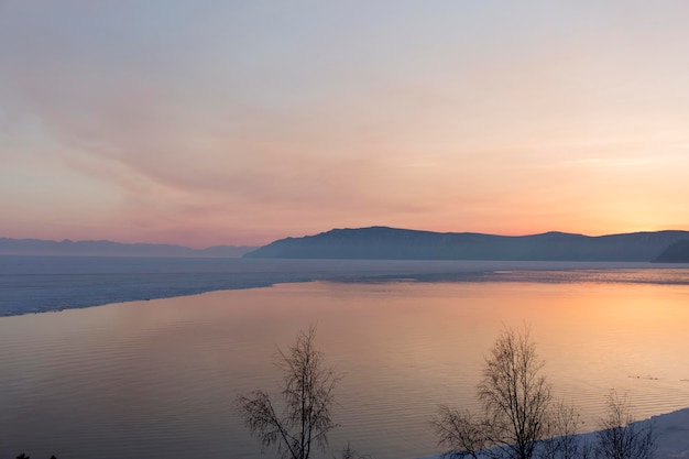 Belo pôr do sol na paisagem de inverno congelada do lago baikal