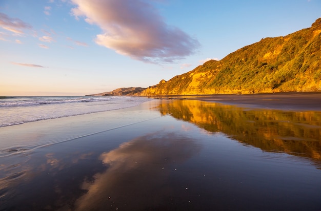 Belo pôr do sol na praia do oceano, Nova Zelândia. Fundo natural e de viagens inspirador