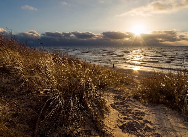 Belo pôr do sol na praia e dunas do mar Báltico na Lituânia Klaipeda