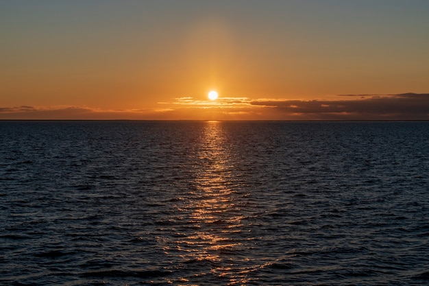 Belo pôr do sol no céu com nuvens no mar. Iluminação hora de ouro.