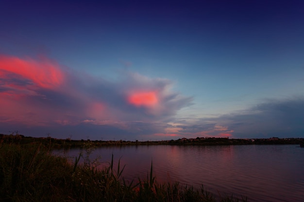 Belo pôr do sol no lago na perspectiva dos juncos