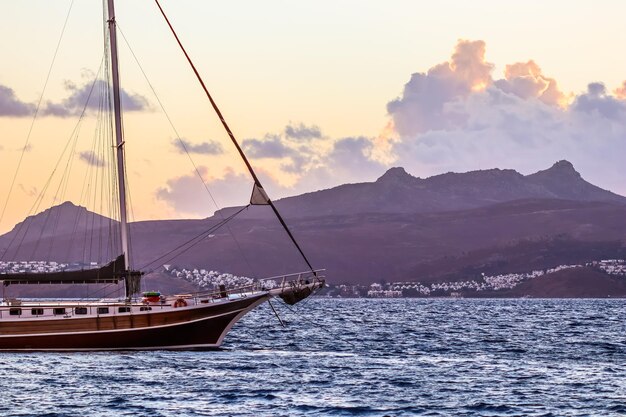 Belo pôr do sol no mar Egeu com montanhas e um veleiro. Seascape, viagens e conceito de natureza. Foto de alta qualidade