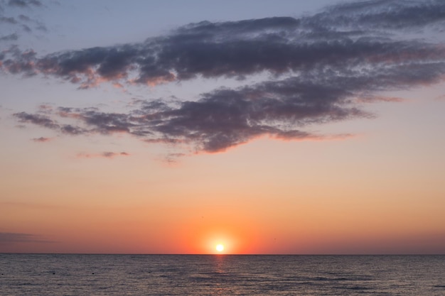 Foto belo pôr do sol sobre o mar com reflexo em nuvens majestosas de água no céu