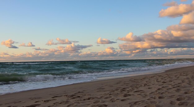 belo pôr do sol sobre o mar com reflexos laranja nas nuvens