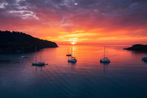 Belo pôr do sol sobre o mar tropical e iate turístico na Ilha Koh Kood