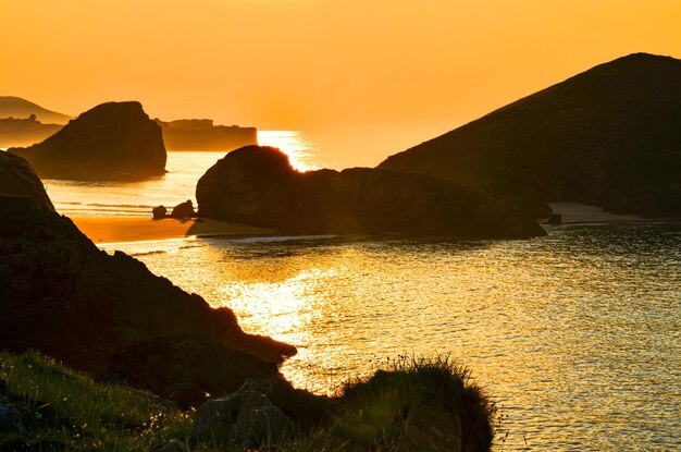 Belo pôr do sol tirado de uma colina em uma praia nas Astúrias, Cantábria, Espanha.