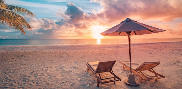 Belo pôr do sol tropical espreguiçadeiras guarda-chuva sob palmeira Paisagem de férias românticas