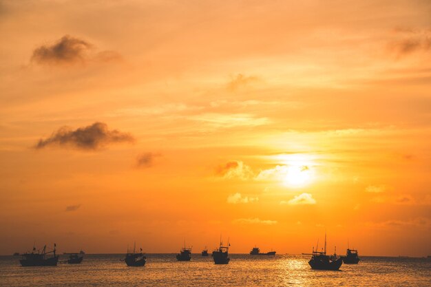 Belo pôr do sol Tropical Seascape com um barco na praia em nublado