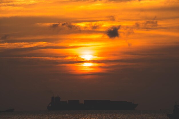 Belo pôr do sol Tropical Seascape com um barco na praia em nublado