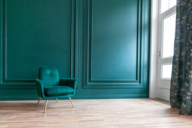 Belo quarto clássico luxuoso azul verde limpo com interior em estilo clássico, com poltrona verde macia. cadeira azul esverdeada antiga vintage ao lado da parede esmeralda. design de casa minimalista.