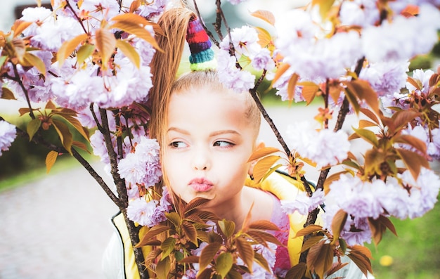 Belo retrato de colegial no jardim da primavera olhar expressivo sorriso de primavera sorrindo criança feliz fashionab