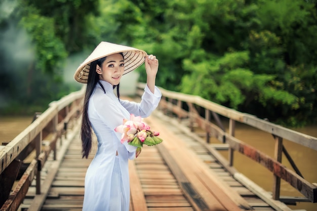 Belo retrato de garotas asiáticas com Ao Dai Ande pela ponte com Lotus, Vietnã mulher de traje de vestido tradicional no Vietnã.