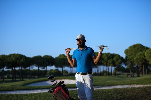 belo retrato de jogador de golfe do Oriente Médio no campo de golfe no belo pôr do sol
