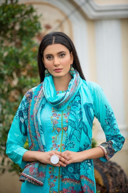 Belo retrato de jovem usando vestido azul no jardim para sessão de fotos de moda