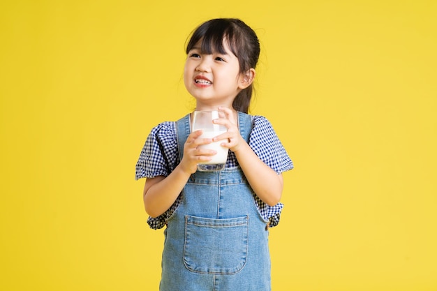 Belo retrato de menina asiática isolado em fundo amarelo