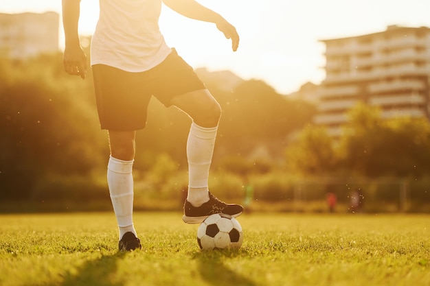 Belo sol jovem jogador de futebol tem treinamento no campo esportivo