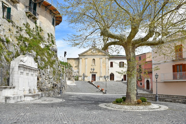 Belo tiro de edifícios e uma árvore na cidade de Macchiagodena, na Itália, com uma árvore e um céu azul