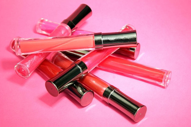 Belos brilhos de lábios em fundo rosa
