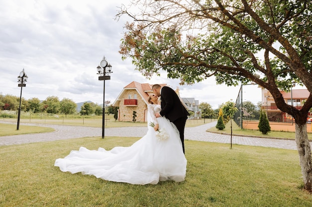 Belos casal o noivo beija a noiva na testa feliz fotografia de casamento