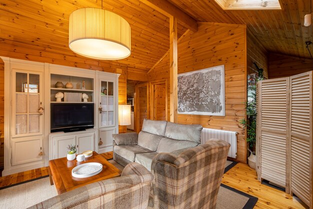 Foto belos interiores de sala de estar aconchegante com sofá e poltronas em uma casa de madeira vida em uma aldeia