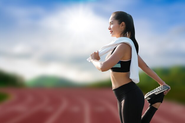 Belos jovens atletas se aquecem antes do treino de corrida em um estádio ao ar livre.