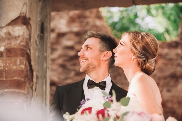 Foto belos recém-casados em pé perto da mesa de banquete em um restaurante vintage