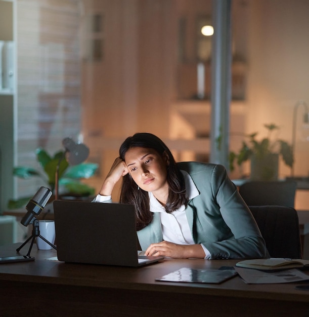 Bem, isso é extremamente chato Foto recortada de uma jovem empresária atraente parecendo entediada enquanto trabalhava até tarde nos escritórios da empresa