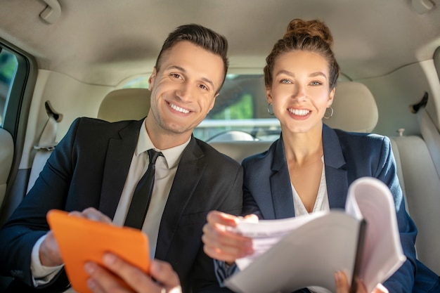 Bem sucedido e confiante homem e mulher sentada no carro