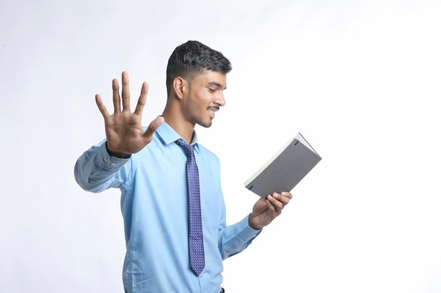 Bem sucedido jovem empresário indiano ou empregado vestindo terno e laticínios barateando em fundo branco.