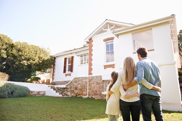 Bem-vindo ao lar Uma família ao ar livre admirando sua nova casa