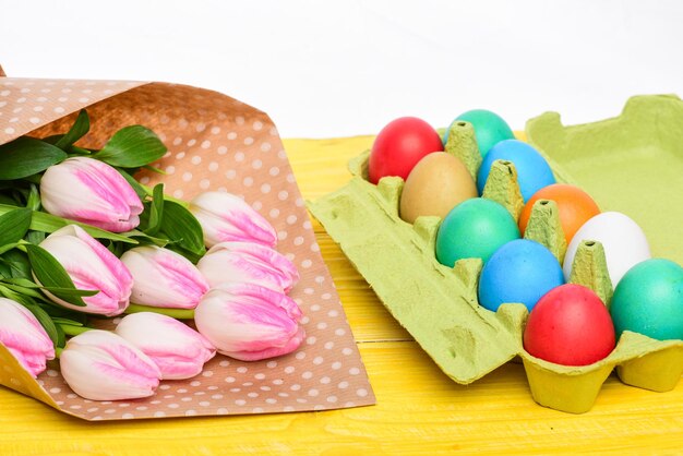 Bemalte Eier in Eierschale Frohe Ostern Frühlingsferien Feiertagsfeier Vorbereitung Eiersuche Tulpenblumenstrauß Gesunder und glücklicher Feiertag Schauen Sie dort hinüber