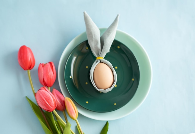 Bemalte Ostereier mit gemischter Farbtulpenanordnung auf einem Holztisch, flache Draufsicht