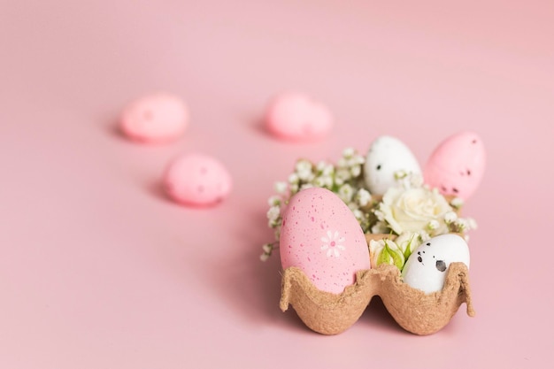 Bemalte rosa und weiße Ostereier in Tablett mit Blumen Bunte Dekorationen Ostergeschenk Rosa Hintergrund Kopierbereich Minimalismus Fröhliches Osterkonzept