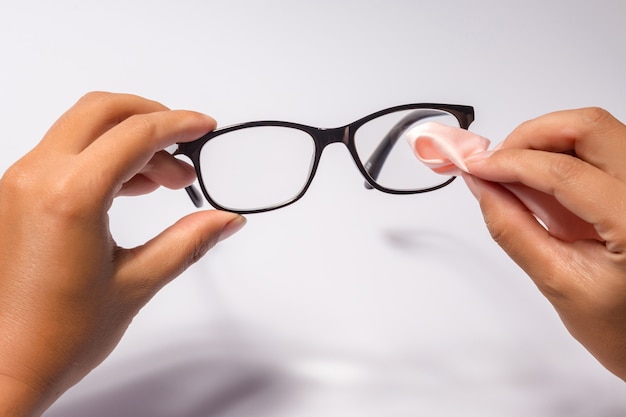 Bemannen Sie das Halten der Brille des blauen Auges mit dem glänzenden schwarzen Rahmen, der auf Weiß lokalisiert wird