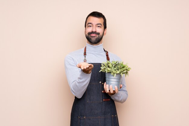 Bemannen Sie das Halten einer Anlage über lokalisiertem haltenem copyspace, das auf der Palme eingebildet ist, um eine Anzeige einzufügen