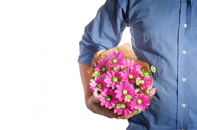 Bemannen Sie das Halten eines Blumenstraußes der rosafarbenen Blumen, die ein blaues Hemd tragen