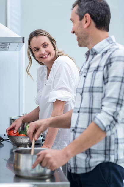 Bemannen Sie das Helfen der schwangeren Frau, Lebensmittel in der Küche zuzubereiten