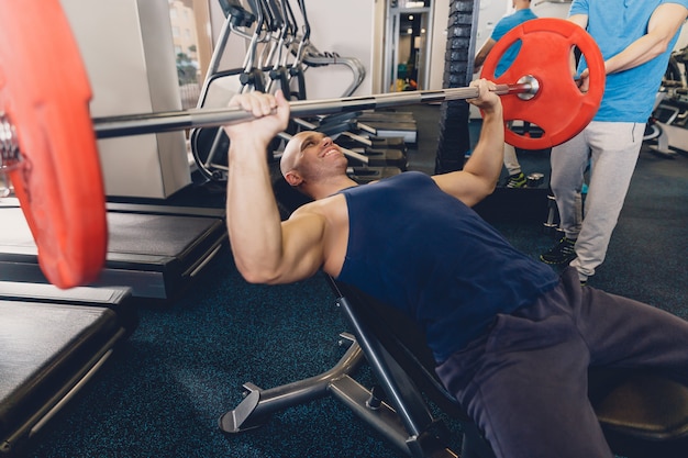 Bemannen Sie das Lügen auf der Bank, die ein Training mit einem Barbell tut.