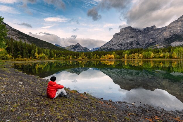 Bemannen Sie den Reisenden, der im Keilteich am Morgen auf Kananaskis-Land sich entspannt