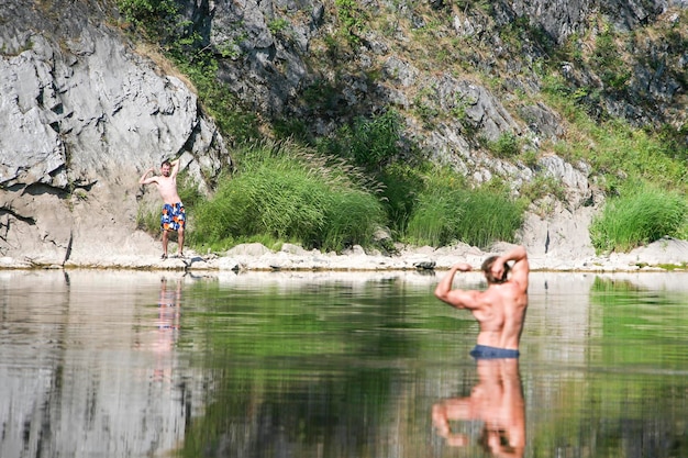 Bemuskelt im Fluss vor dem Hintergrund eines mageren Kerls