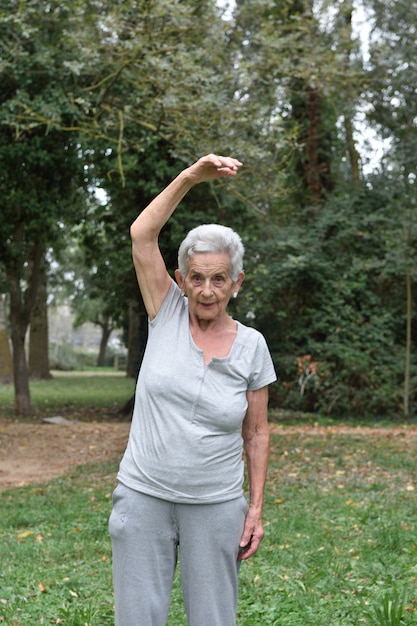 Übendes Yoga der älteren Frau draußen