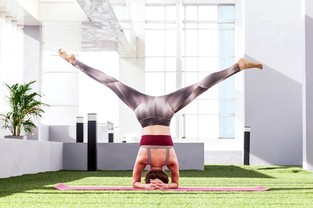 Übendes Yoga der Frau im Park - gesunder Lebensstil