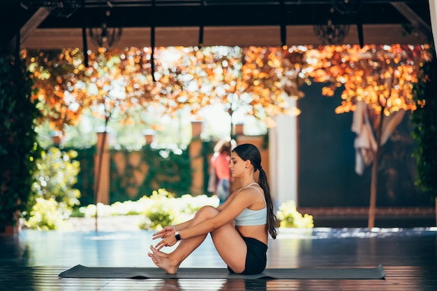 Übendes Yoga der jungen Frau Führt eine Übung durch