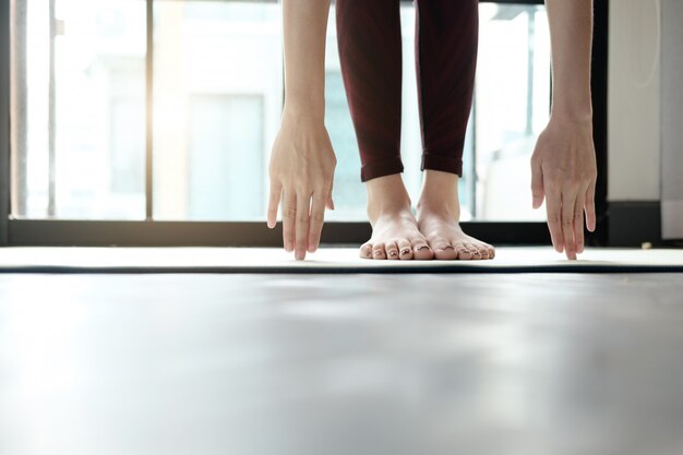 Übendes Yoga der jungen Frau zu Hause.