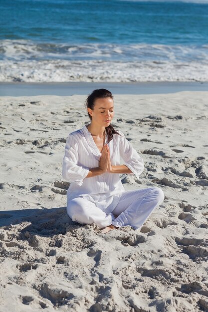 Übendes Yoga der ruhigen Frau gegen das Meer