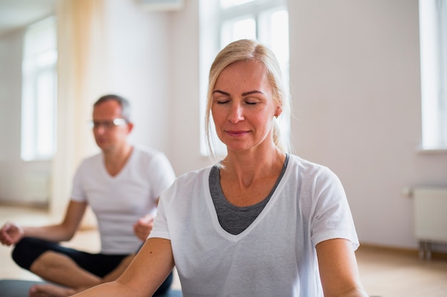 Übendes Yoga des erwachsenen Mannes und der Frau