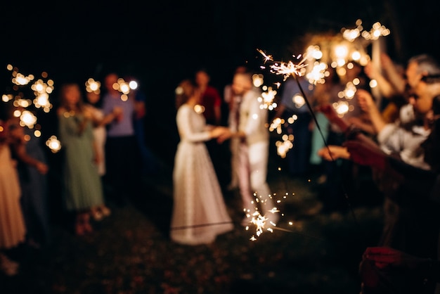 Bengalas en la boda, una pareja de recién casados en el fondo