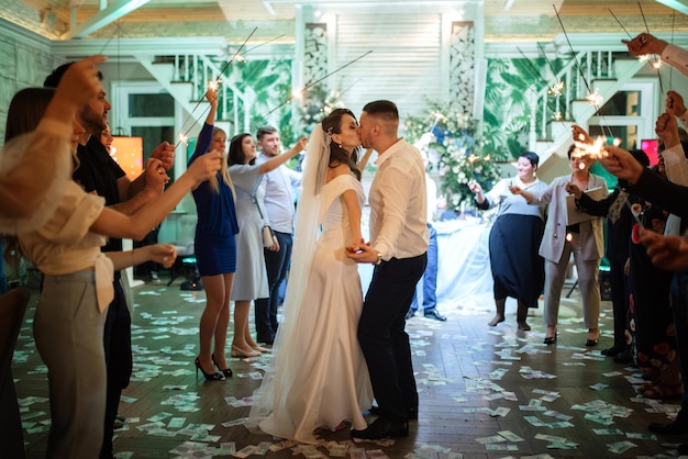 Bengalas en la boda de los recién casados en manos de alegres invitados.